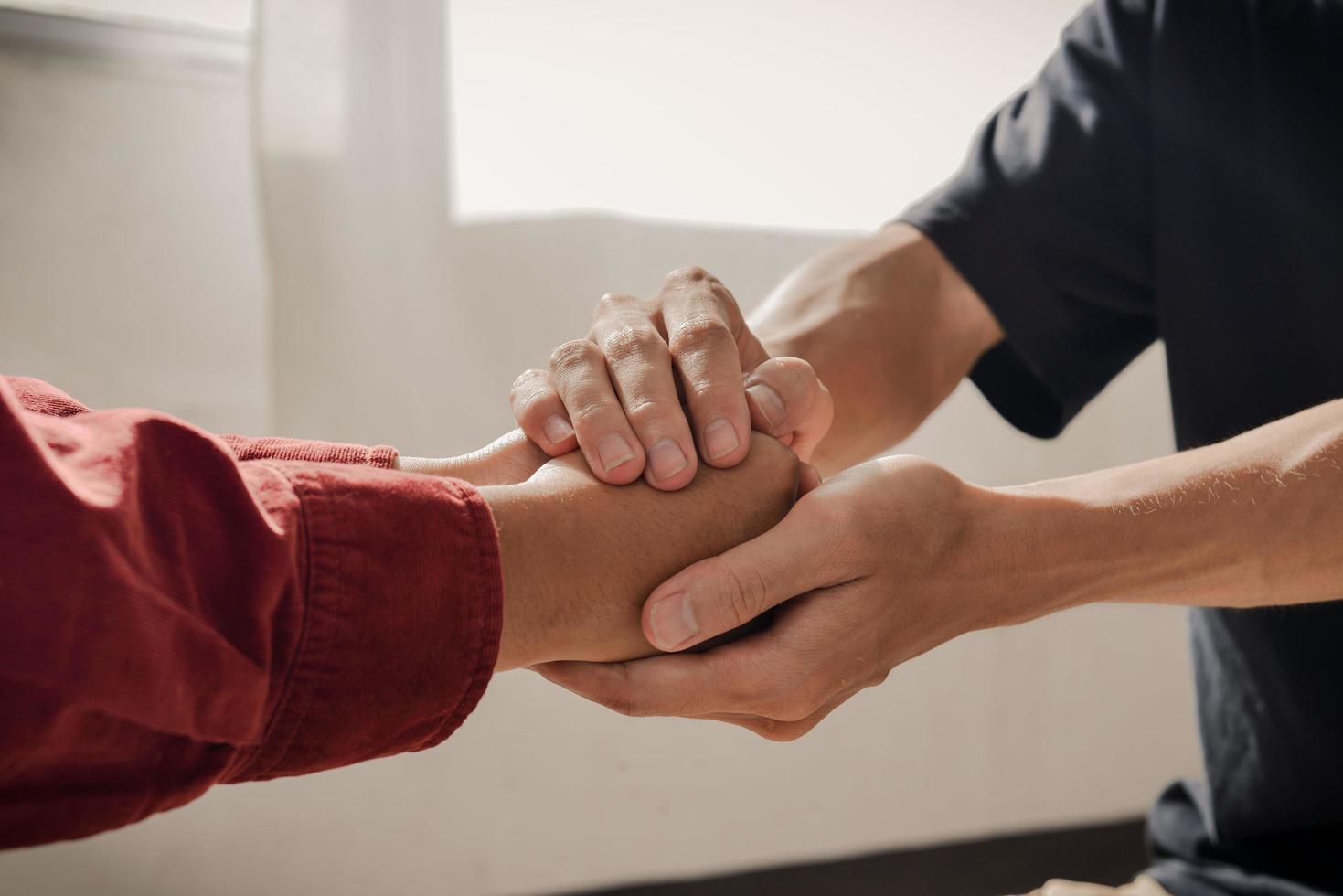 Två personers händer som möts i omtanke